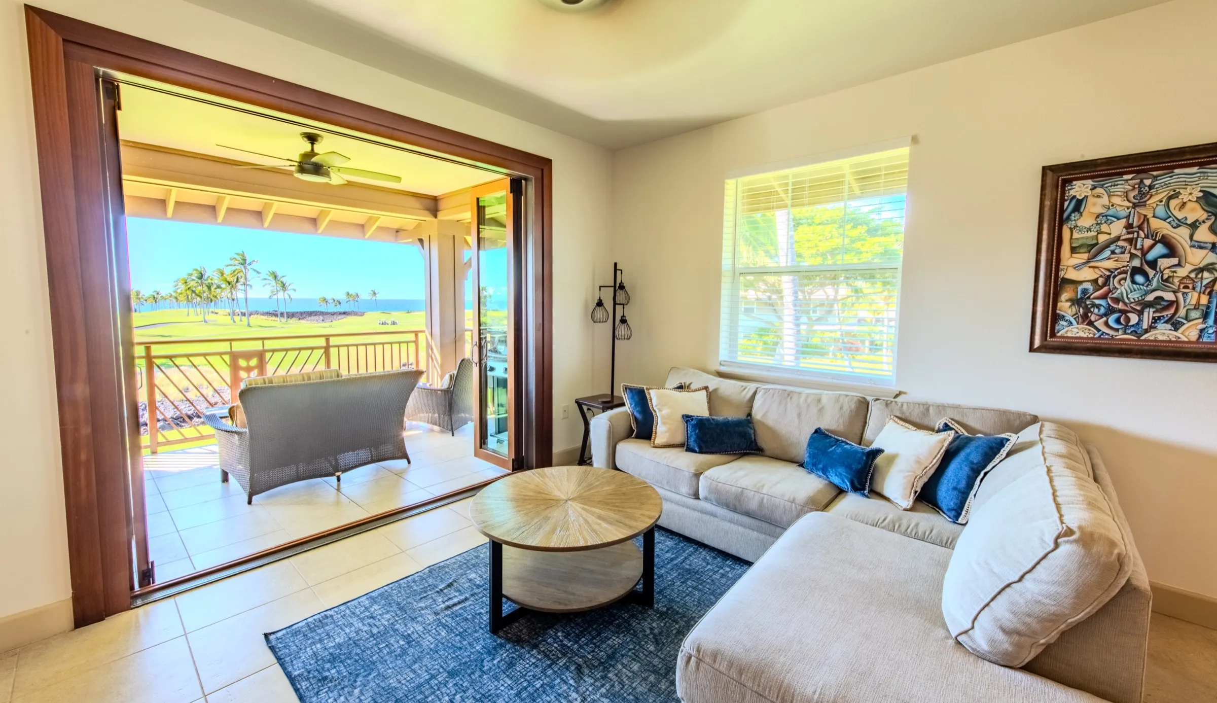 Great room with a sectional sofa and folding doors open to the ocean-view lanai