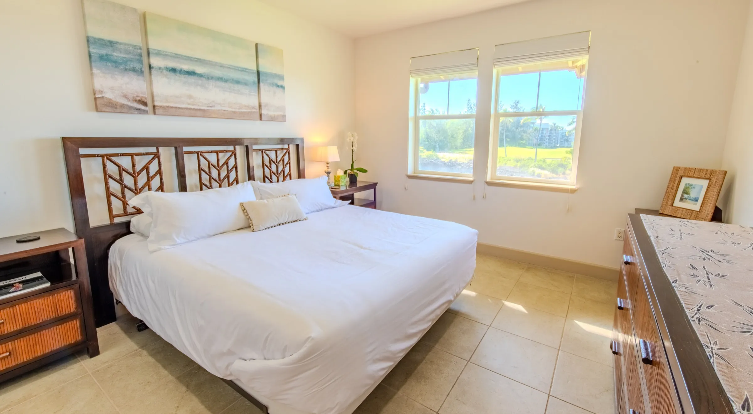 Primary bedroom with a king bed and coastal artwork