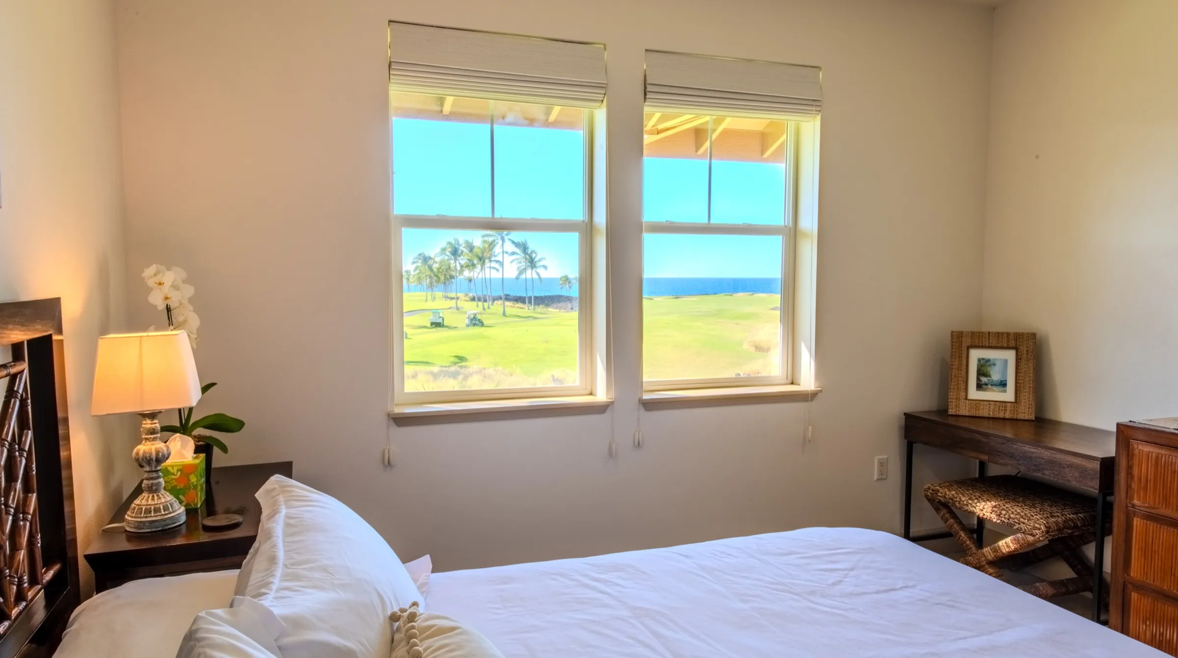 Primary bedroom windows framing the golf fairway and the ocean