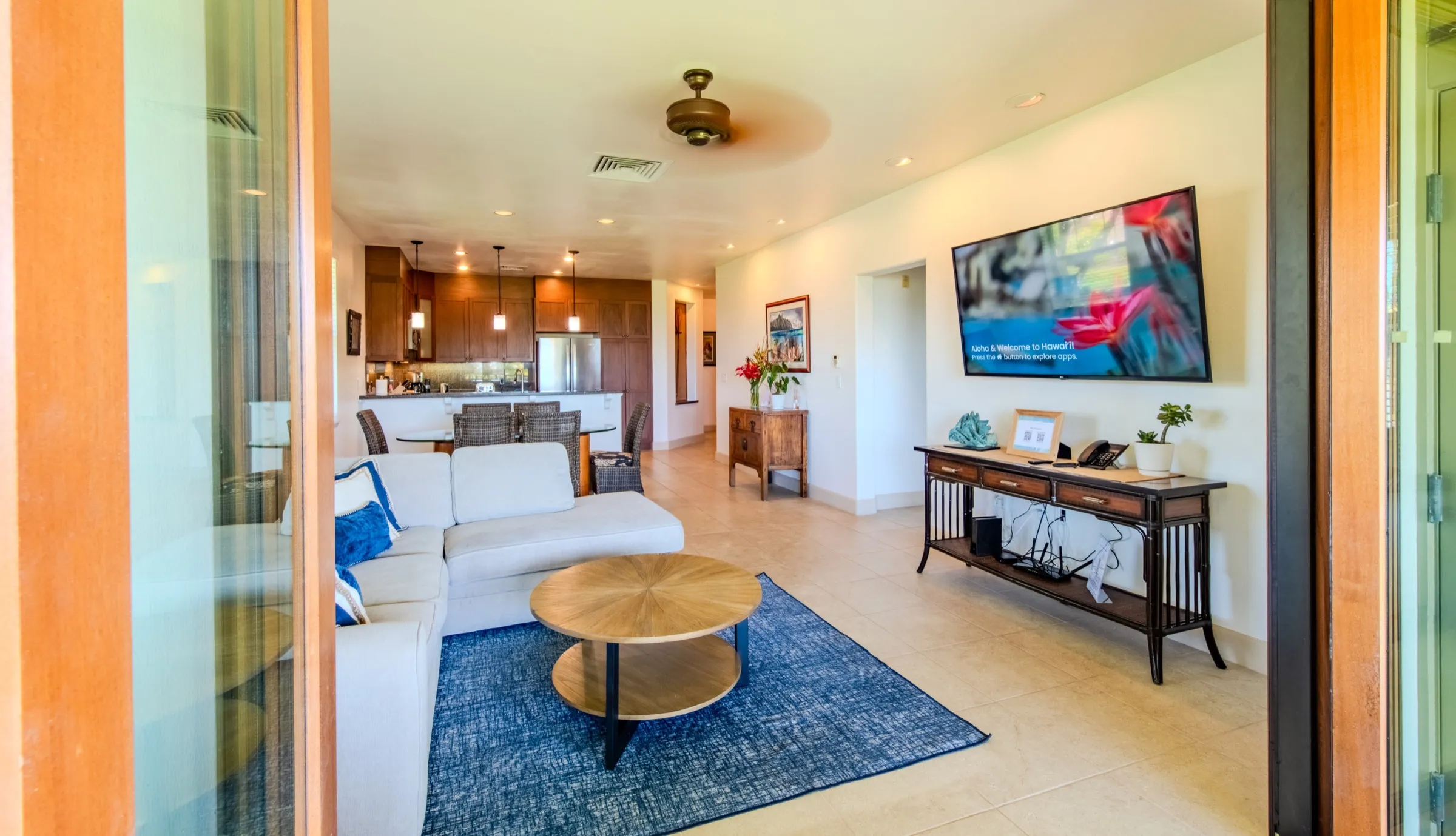 Open-plan living, dining, and kitchen with a wall-mounted television