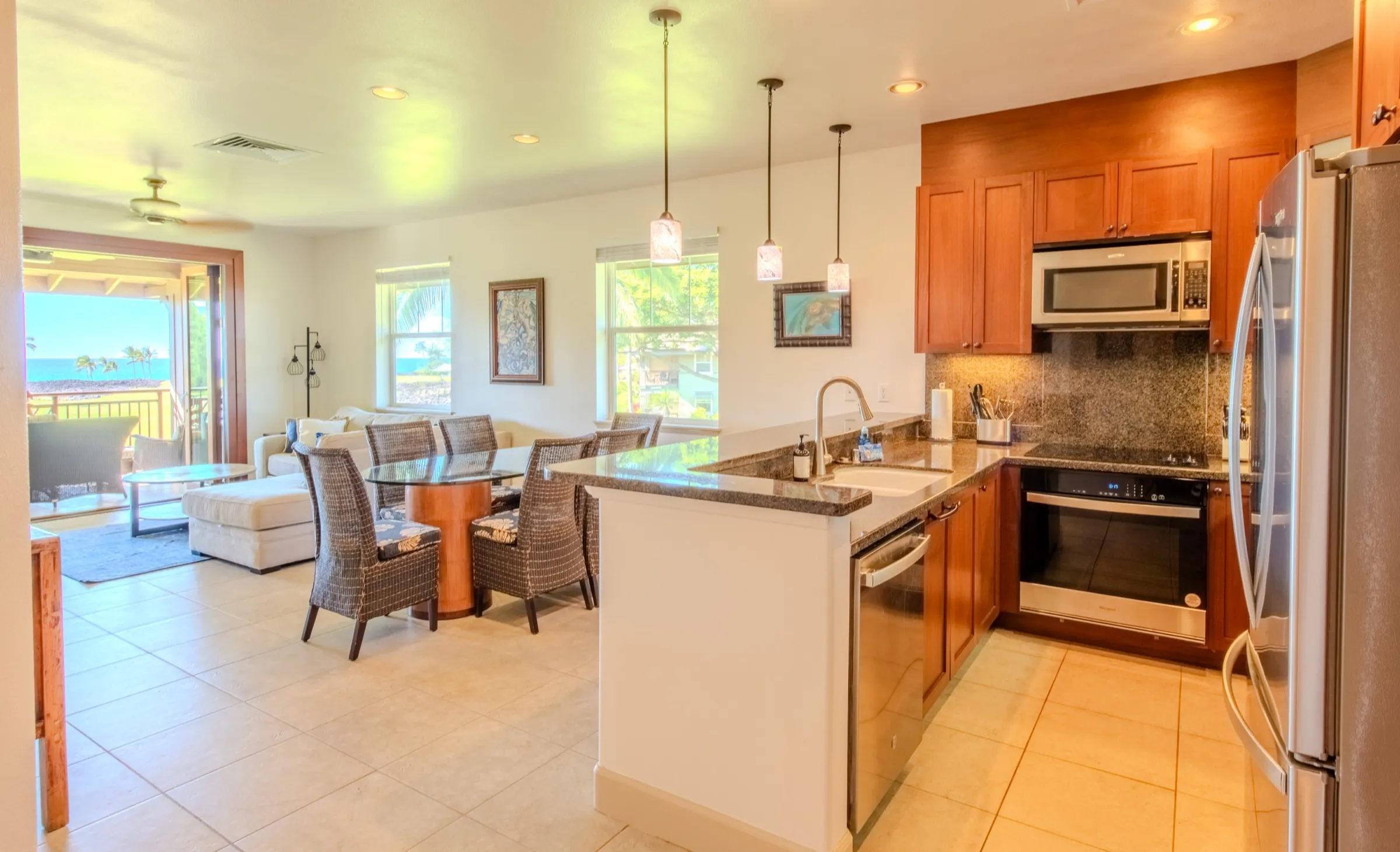 Granite kitchen peninsula with breakfast seating beside the great room